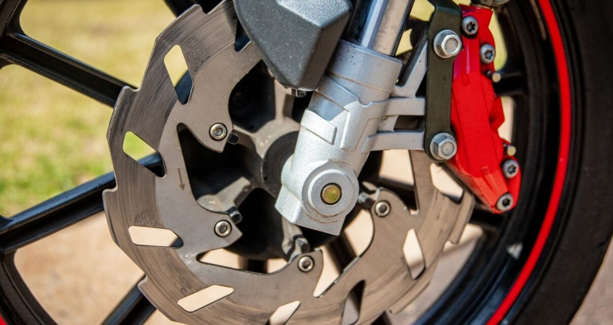 Close-up of a motorcycle’s ventilated brake disc and red caliper