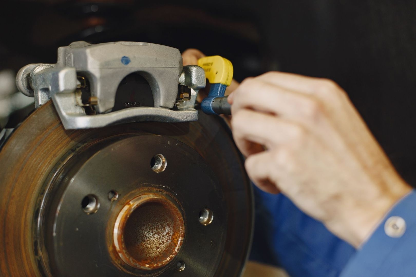 Mechanic servicing a motorcycle brake caliper and rotor assembly